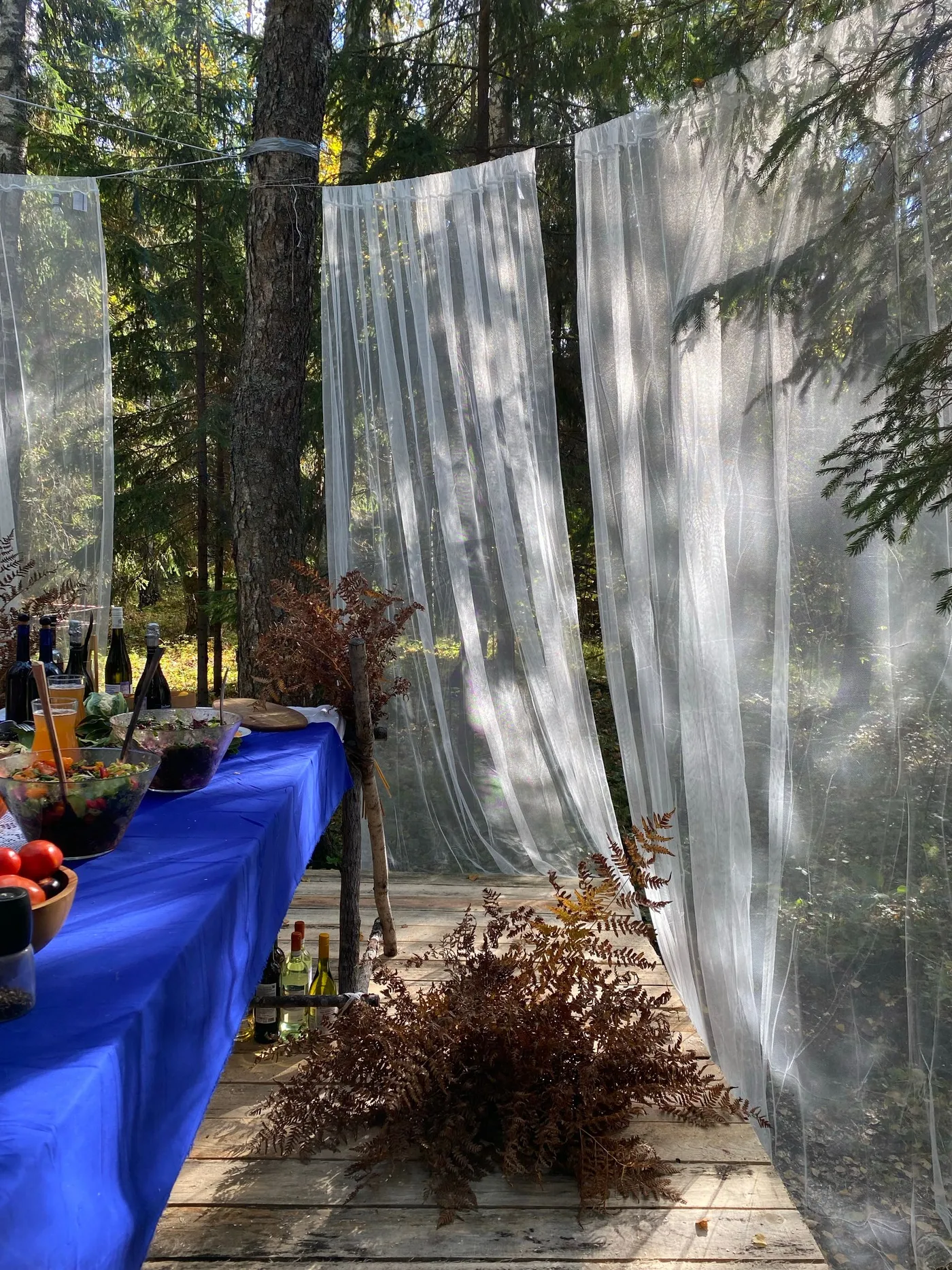 Table de réception dans un jardin, voiles blancs suspendus
