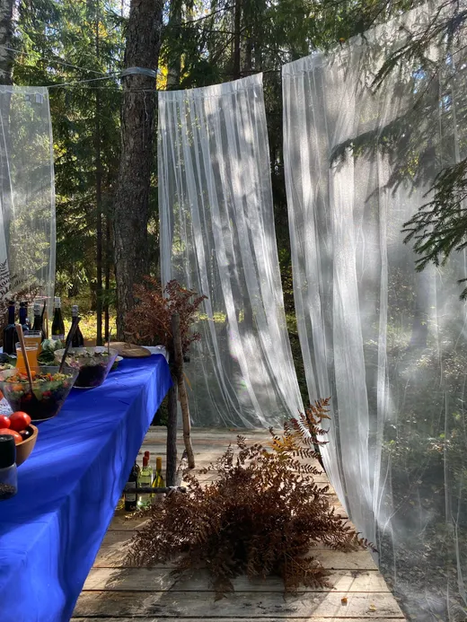 Table de réception dans un jardin, voiles blancs suspendus
