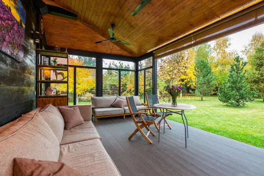 Terrasse couverte avec canapés et vue sur le jardin